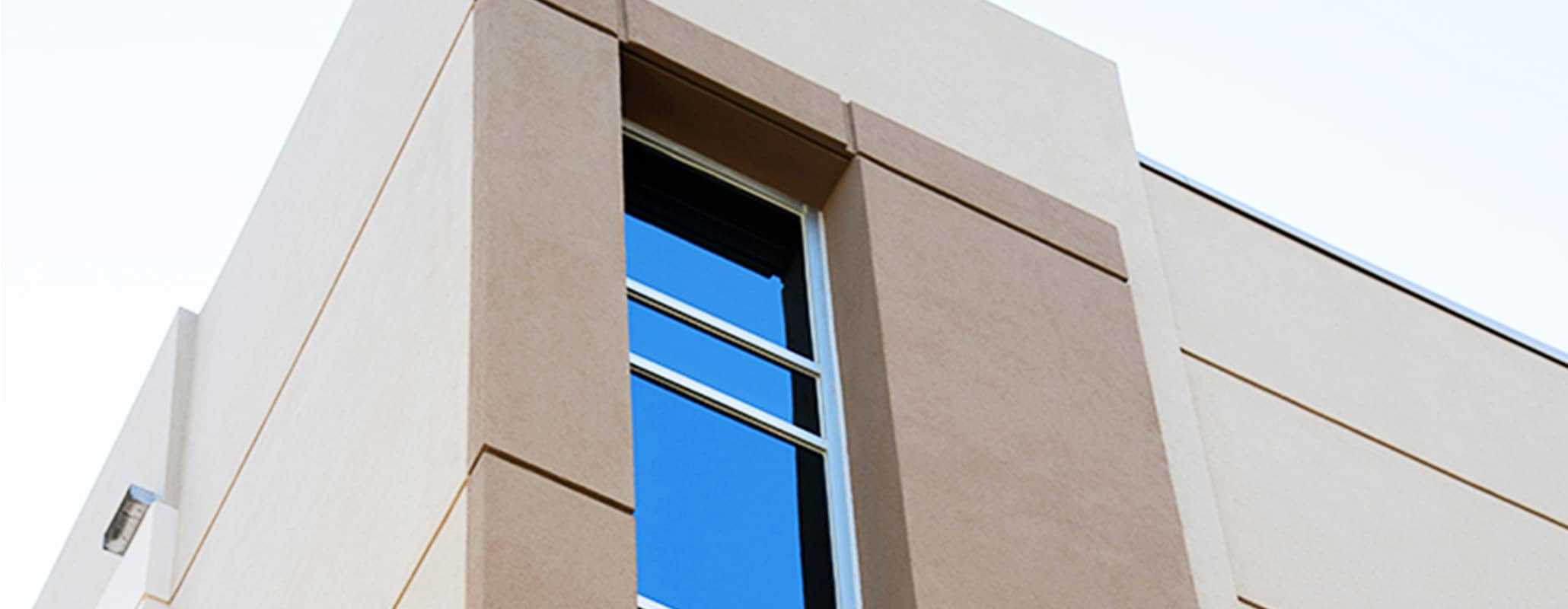 Aldora SMI-090 windows run down the corner of a commercial cement building