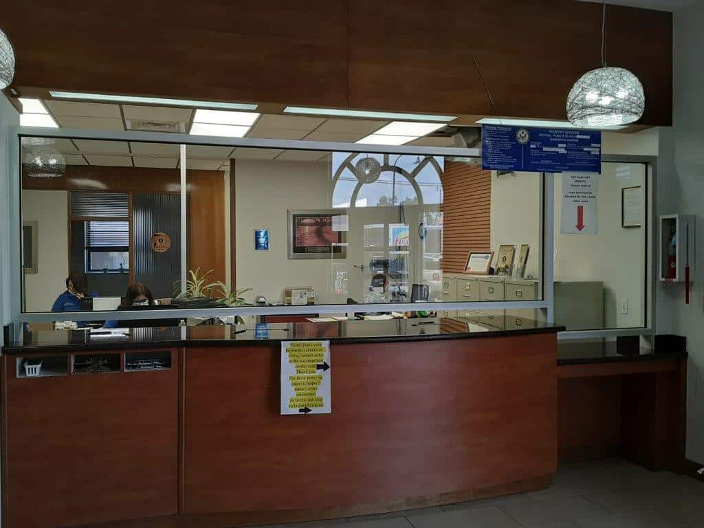 Interior glass partition fixated on an office's front desk with two women working behind.